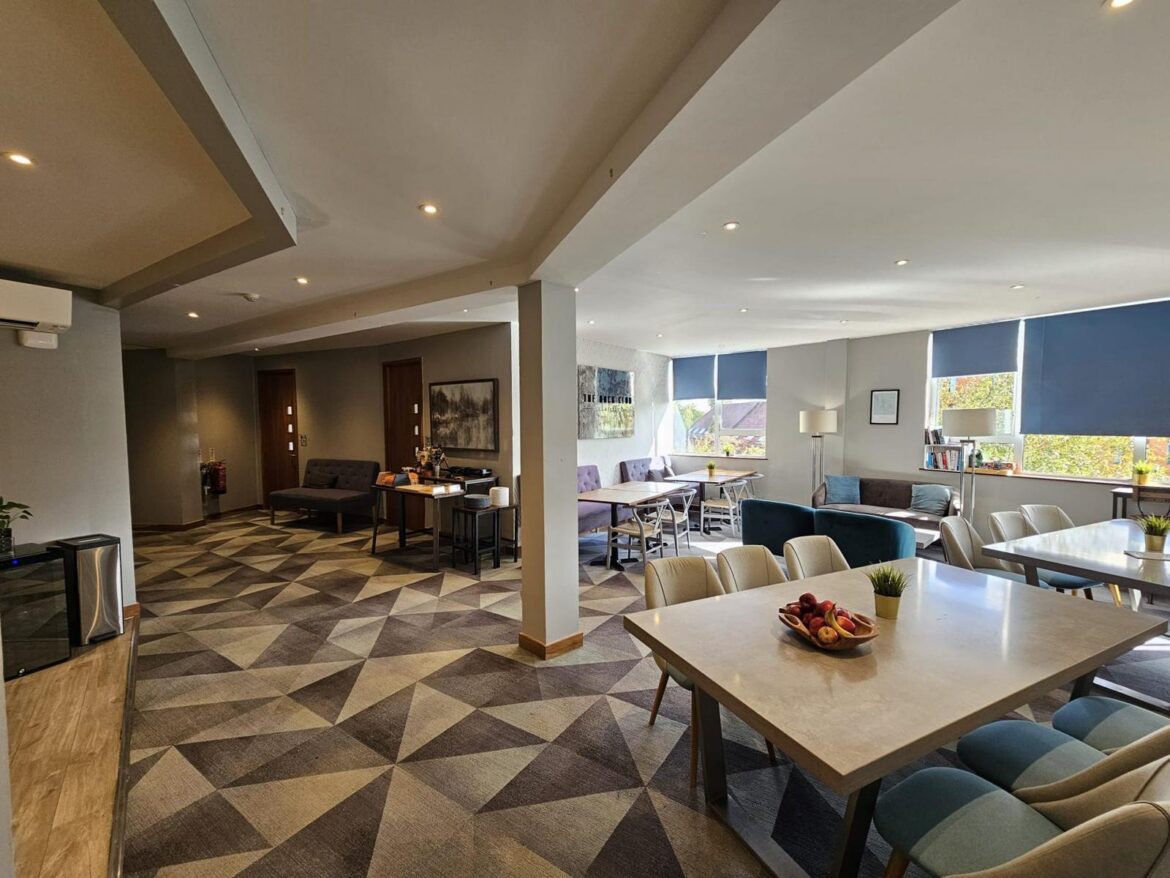 Student breakout and dining area with tables and sofas at Prama House, Oxford