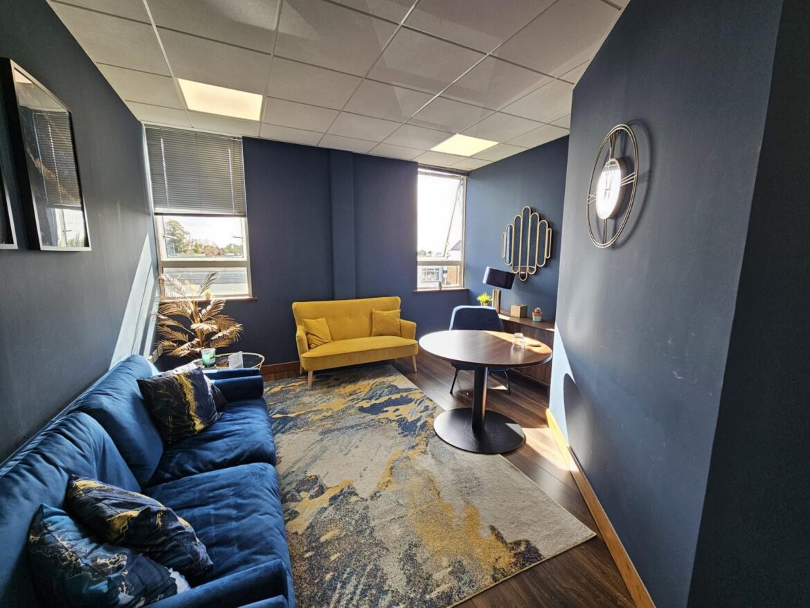 Lounge with blue and yellow sofas at Prama House, Oxford